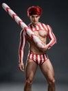 Men's Christmas candy cane costume with red-and-white cropped top and briefs, holding an inflatable candy cane diagonally